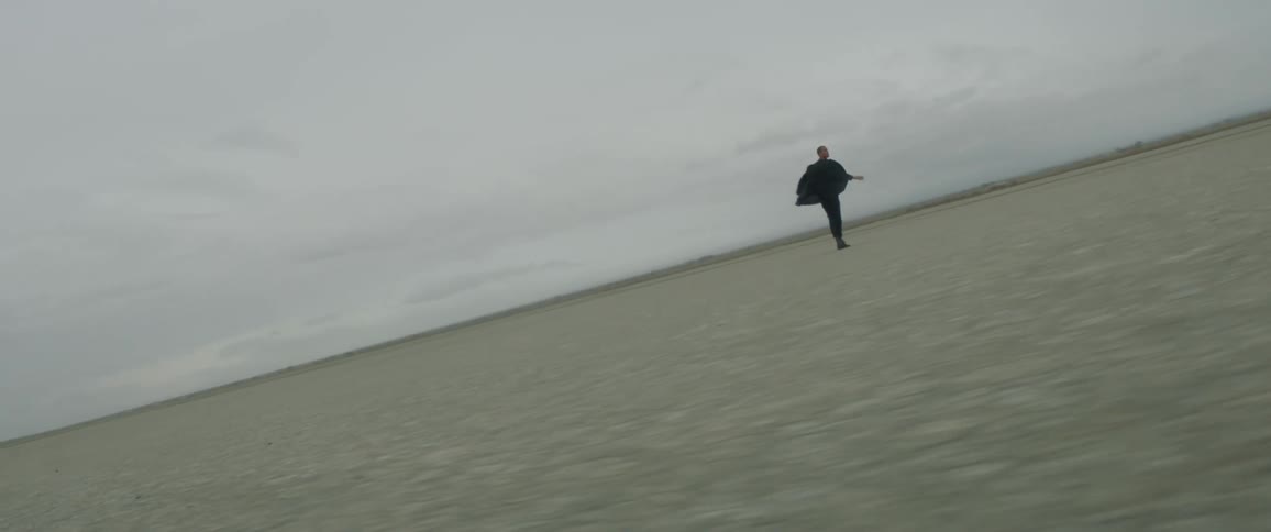 A man is slowly moving and turning around on the field