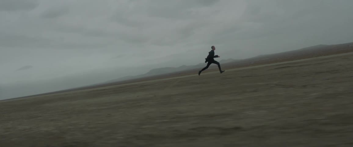 Man running as fast as he can over flatland wilderness on cloudy evening