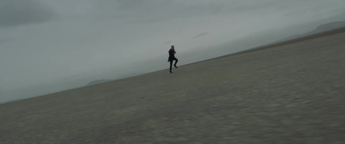 A man runs across a desert field