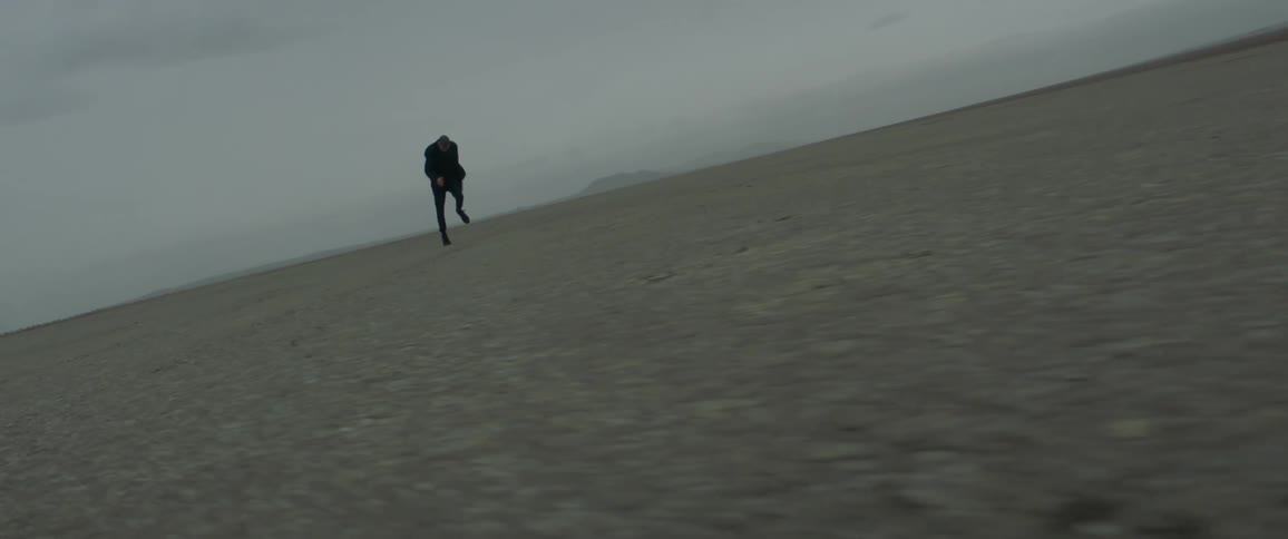 Man running as fast as he can over flatland wilderness on cloudy evening