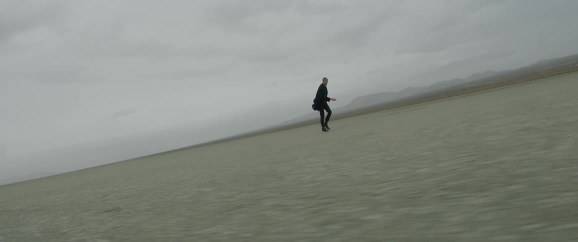 A man is moving across the field on a cloudy day