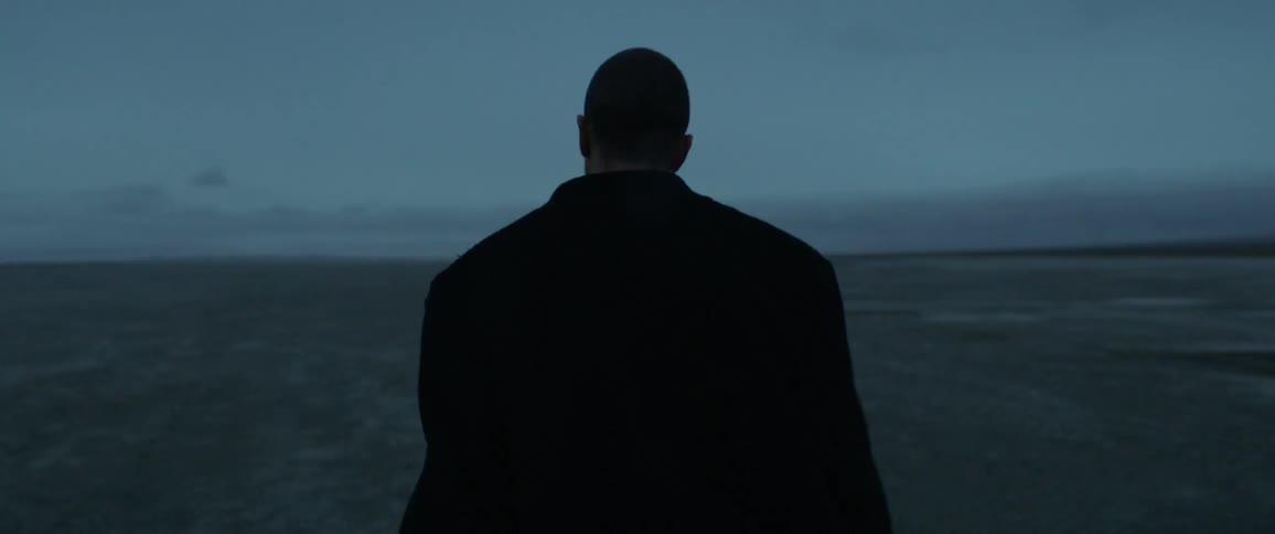 A man walks outside at dusk