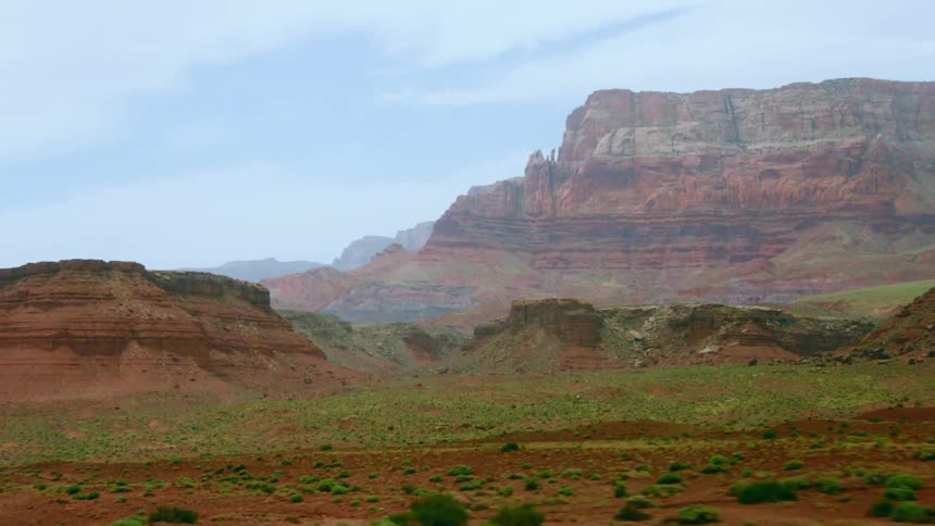 A landscape with plants with a canyon the sky and the clouds in the background