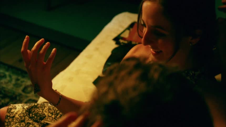 Woman sitting in a couch shows his couple a small fin in the back of her hand