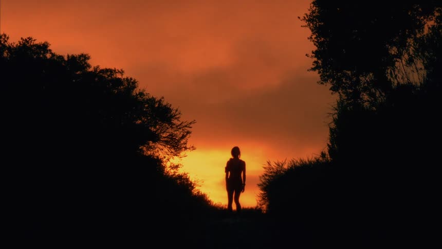 A woman looks at the landscape and then turns around and runs