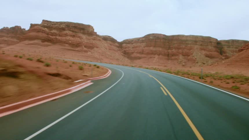 View from inside a car of the road and badlands