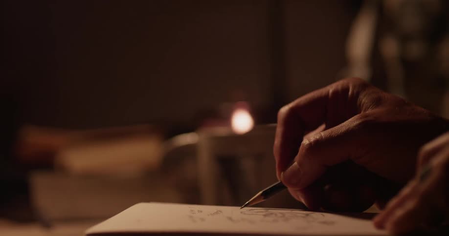Person drawing a picture in a book in pencil