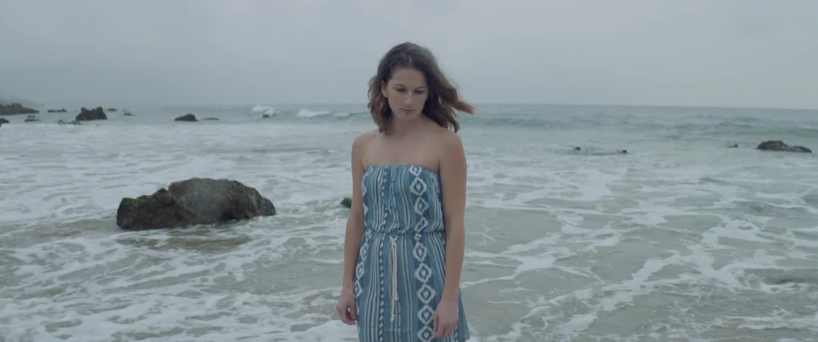 A woman is standing in the water of an ocean