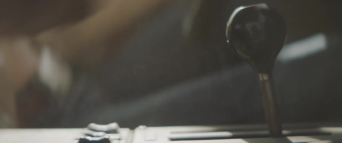A person is shifting the gears in a vehicle