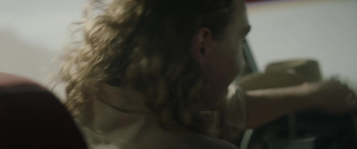Woman driving erratically in a dusty area and enjoying it