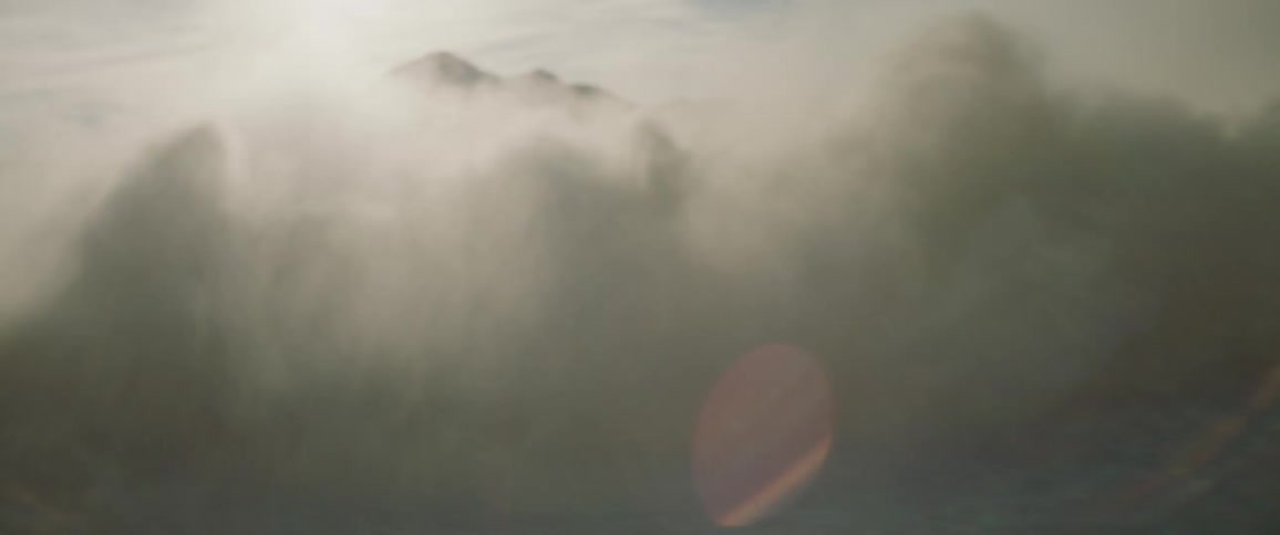 A man rides on the top of a car doing donuts