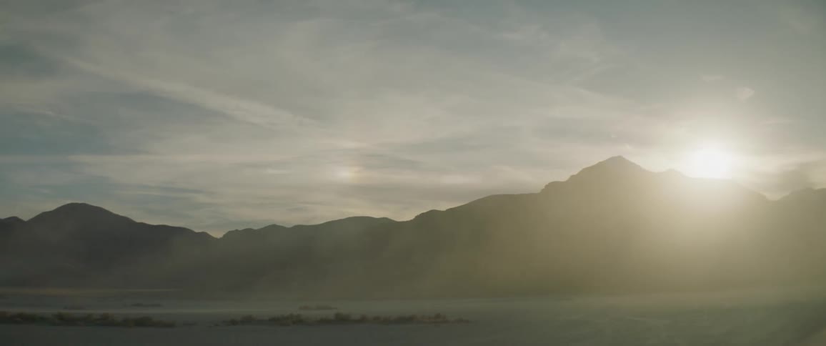 Sun rises over hills on a cloudy day