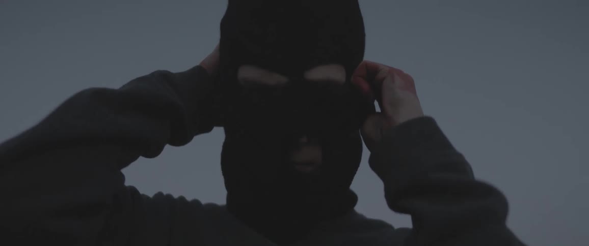 A man covers his face with a ski mask