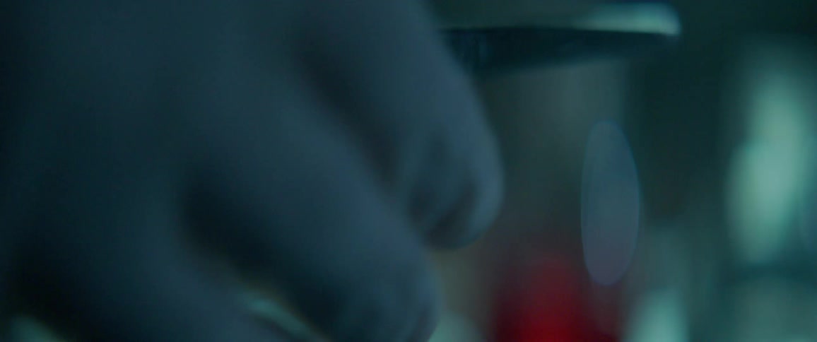 A person wearing latex gloves is opening and closing scissors in a lab