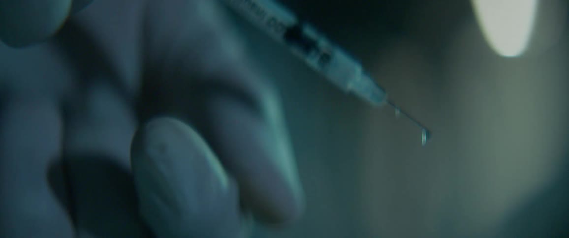 A person squirts medicine out of a syringe
