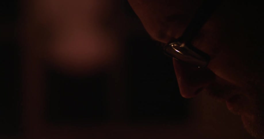 Spectacled man looking down and then around indoors