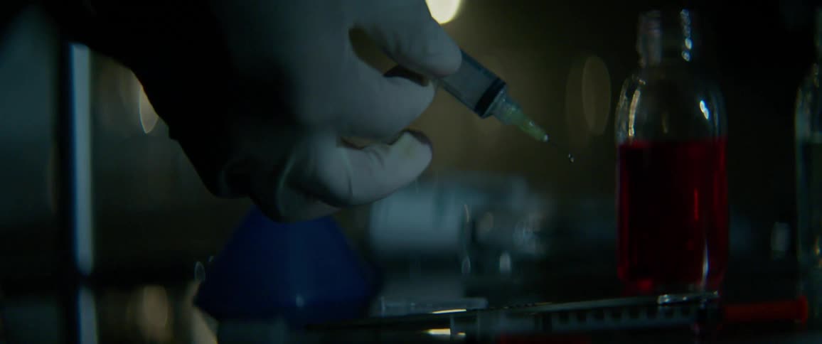 A medical professional squirts medicine from a syringe