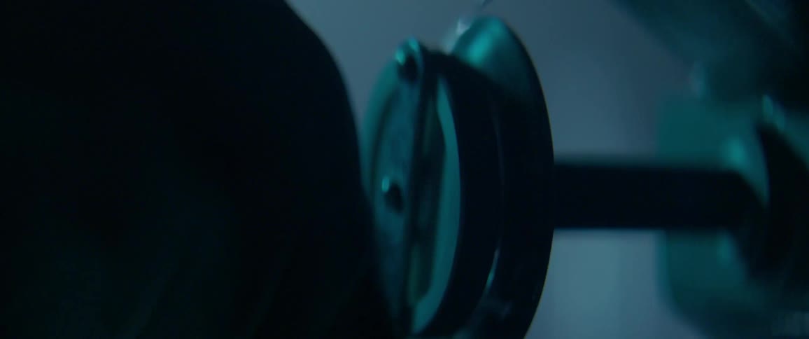 A man wearing latex gloves is turning a knob