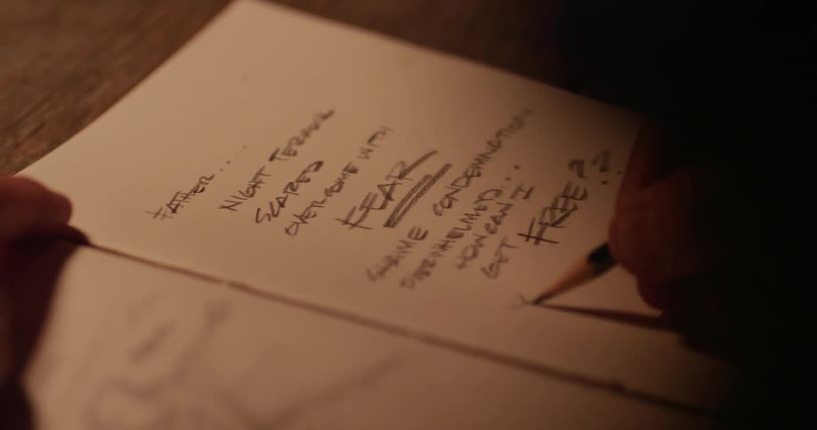 A man writes on a piece of paper