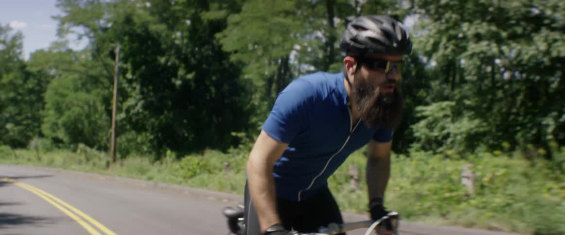 A man rides a bike on the road during the day