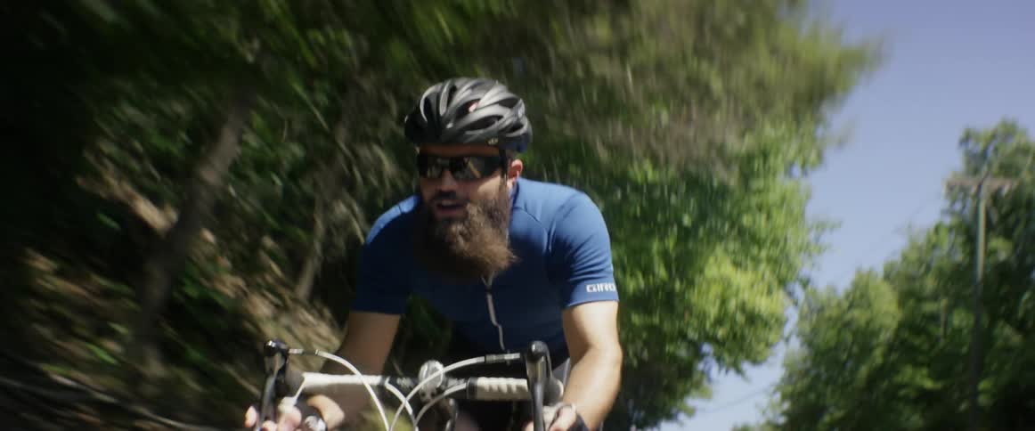 A man is riding his bike down a road