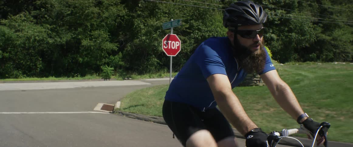 A man bicycles outside on a sunny day