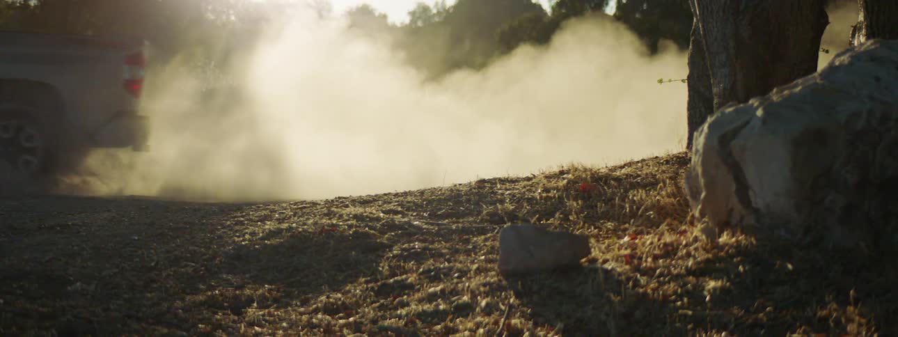 A person driving a truck down a dirt road