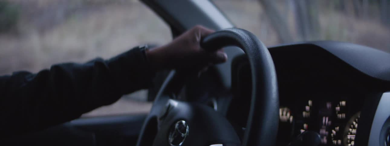 Man turns steering wheel to control the direction of a vehicle