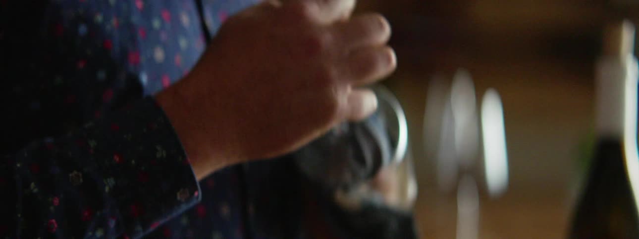 A person uses a cloth to clean the inside of a wine glass