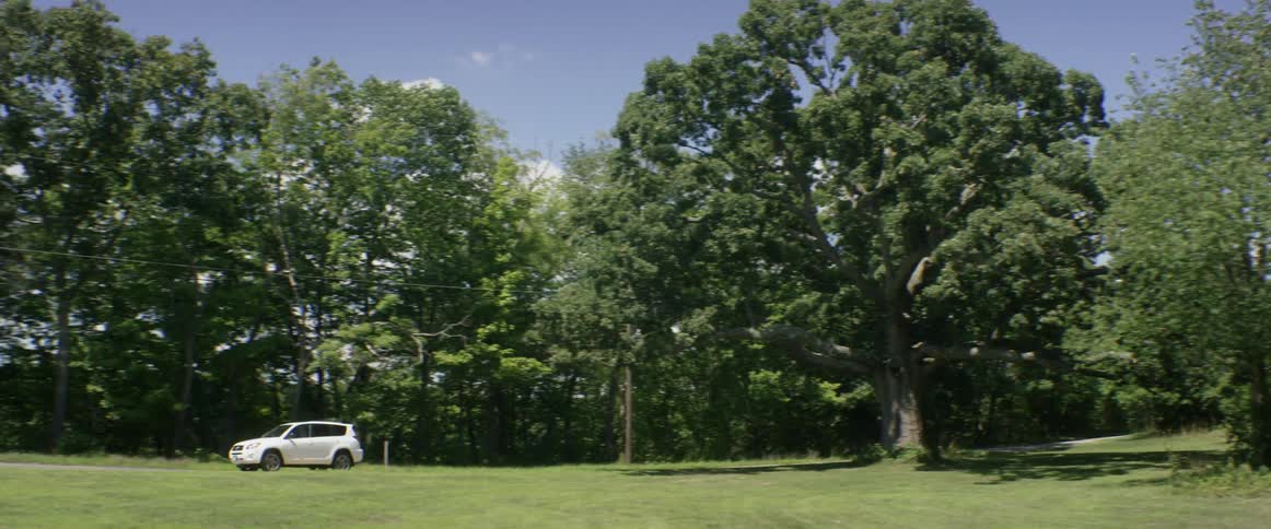 A car drives across a grassy field