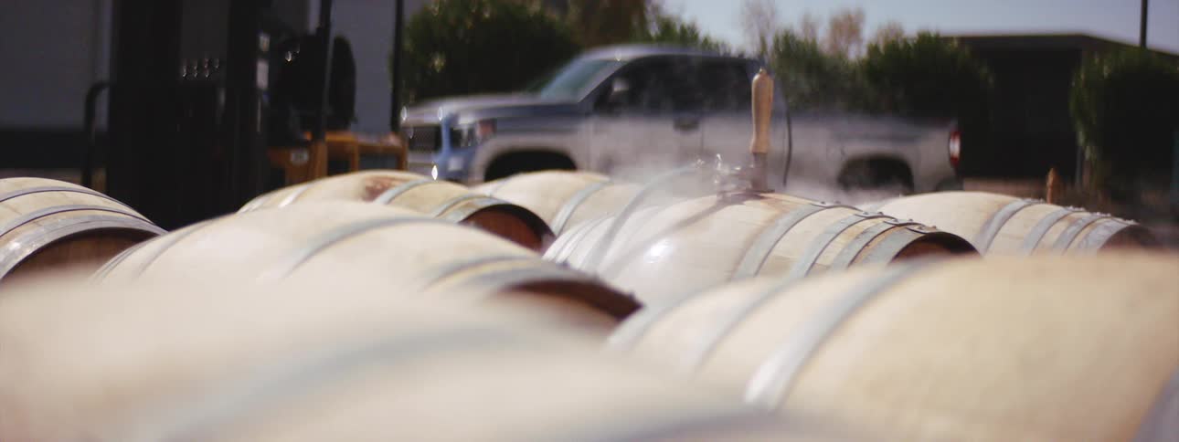 Wooden barrels outside a warehouse being treated with steam