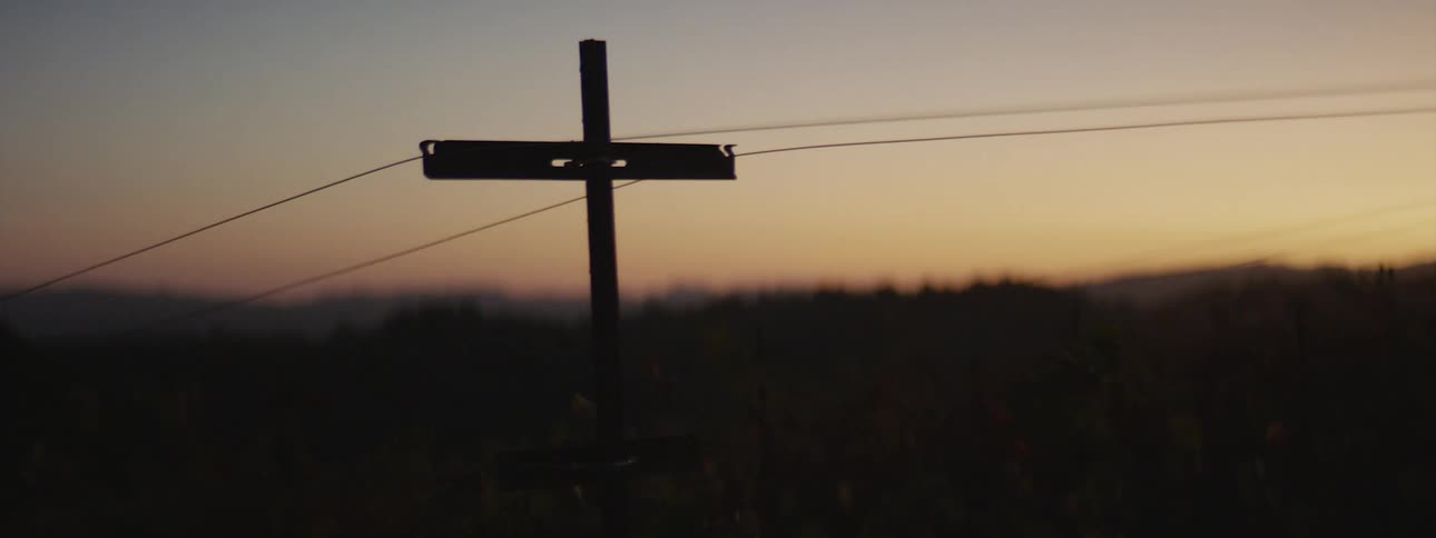 A silhouetted rural power line at dusk