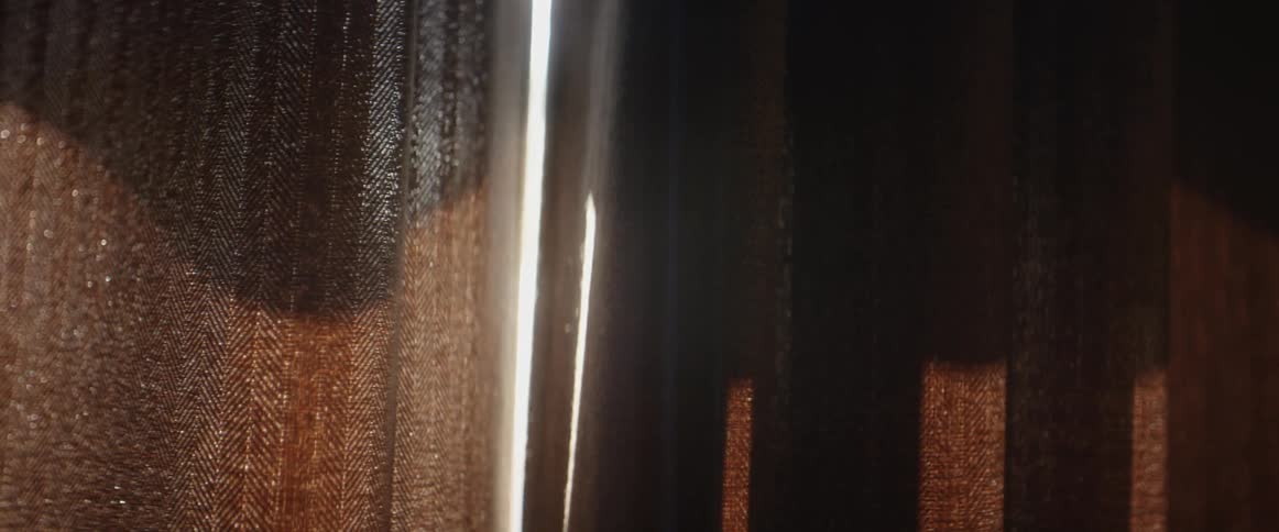 A window is covered by heavy curtains in a dark room