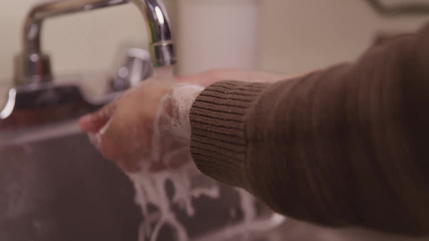 A woman washing her hands at home