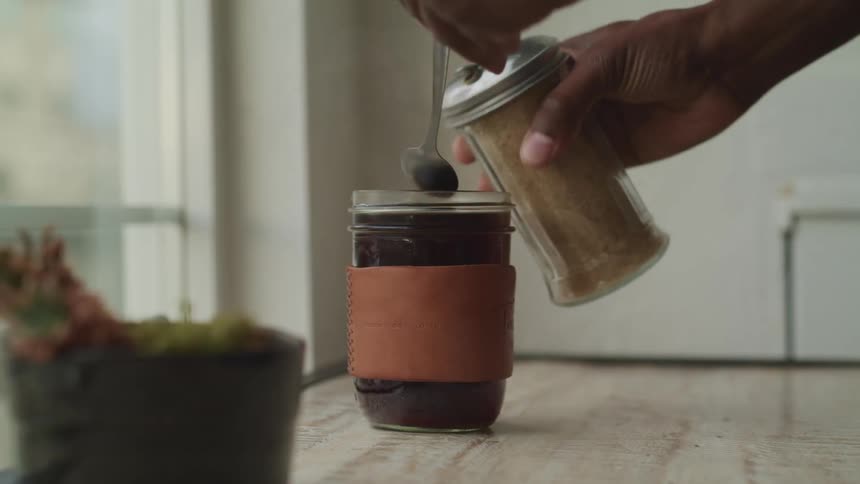 A person is mixing a cup of coffee