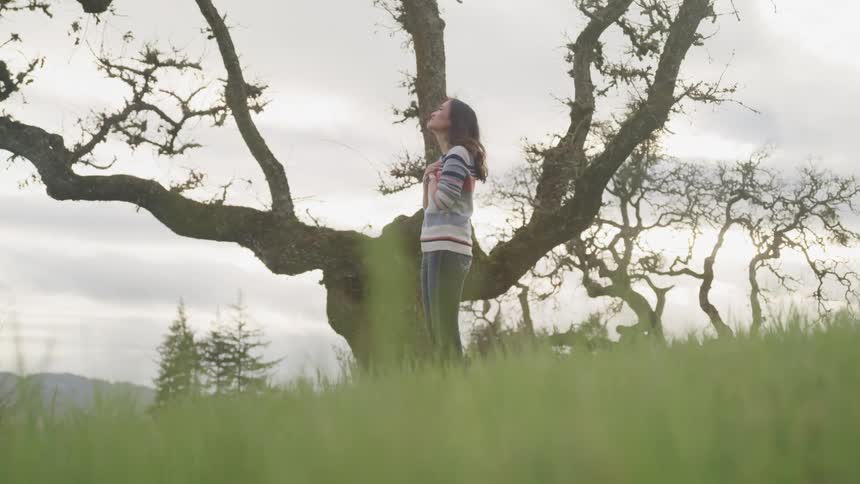 A woman is standing outdoors in a rural area