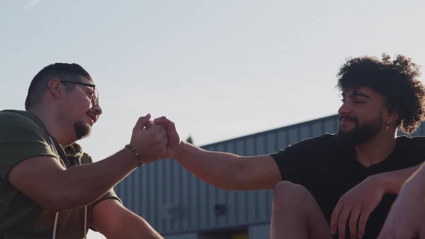 Two friends shake hands outside