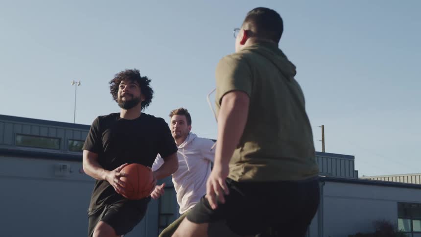 A group of men are playing basketball outdoors
