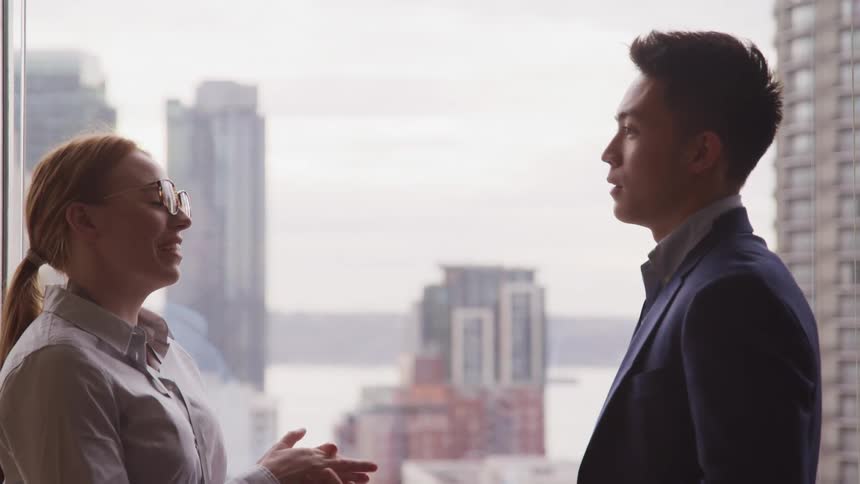 Two people speaking inside an office building