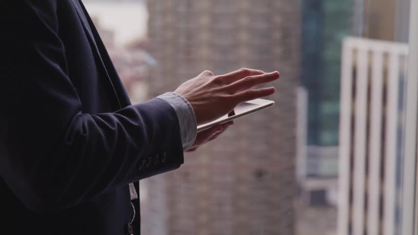 A man wearing a suit is using a cellphone