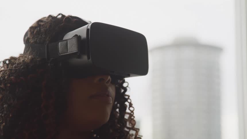 A teenage girl with a virtual reality set on at home