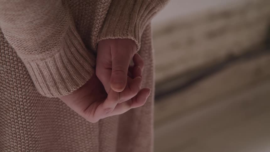 A woman is holding her hands together indoors