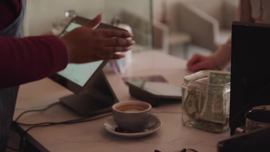 A person is buying coffee in a cafe