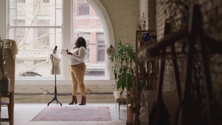 Overweight black woman stands in front of a mannequin torso