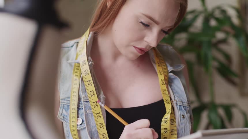 A seamstress is taking notes in a pad