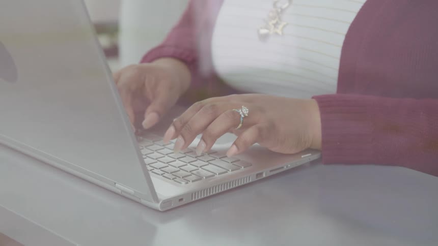Woman types on a laptop keyboard
