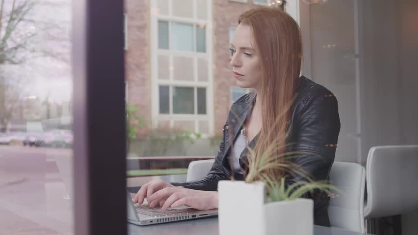 A woman in an office works on her laptop