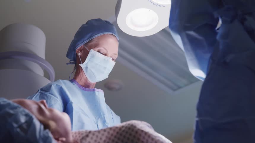 A surgeon performing surgery on a patient