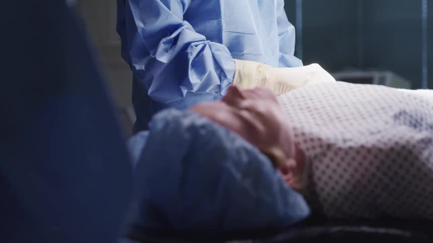 Surgeon performing surgery on a sedated patient in an operating room