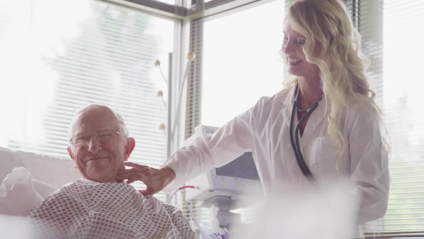 A nurse checks an elderly patients vitals in the hospital